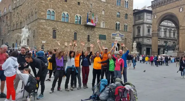Un gruppo di escursionisti festeggia a Firenze, pronto per le tappe della Via degli Dei.