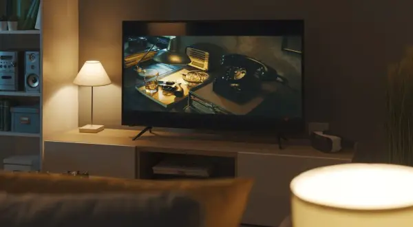 Na ekranie telewizora w jakości **full HD jaka to rozdzielczość** widać scenę z lat 40. z telefonem, pistoletem i whisky.