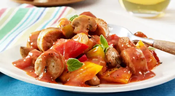 Herzhaftes Wurstgulasch mit Bratwurst, Tomaten und Pilzen, garniert mit frischen Kräutern. Ein deftiges Gericht für Genießer.