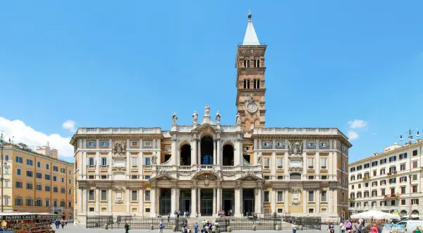 Bazylika Santa Maria Maggiore w Rzymie, z charakterystyczną wieżą zegarową, na tle błękitnego nieba.