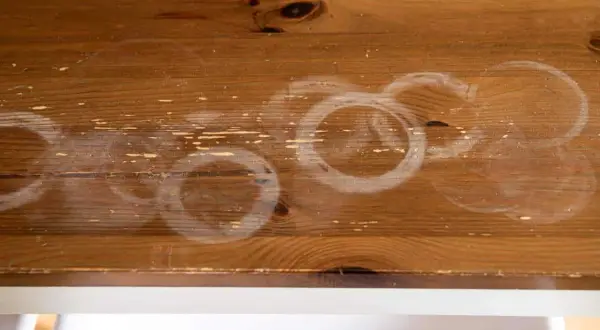 Cercles blancs sur bois : une tache de chaleur laissée par une tasse chaude.