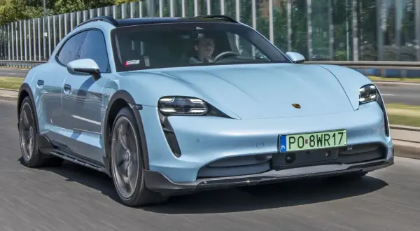 Jasnoniebieski Porsche Taycan Cross Turismo w ruchu. Sprawdź aktualną porsche taycan cena i możliwości tego elektrycznego kombi.