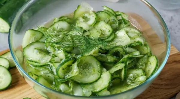Frischer gurkensalat wie bei Oma, mit Dill garniert, in einer Glasschüssel.