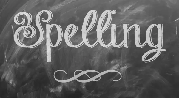 Het woord "Spelling" is met sierlijke letters op een krijtbord geschreven. Een decoratieve krul siert de onderkant.