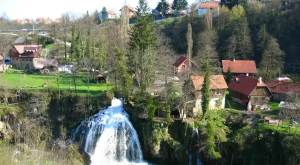 Magnifique cascade en Croatie, avec des maisons traditionnelles nichées dans la verdure. Un paysage pittoresque.