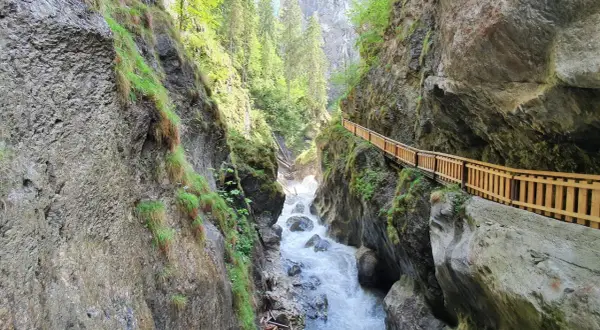 Wilder Wasserfall bei Zell am See, mit Holzsteg entlang der Felswand.