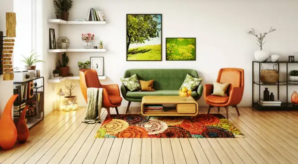 Un salon moderne et chaleureux avec un canapé vert, des fauteuils orange, un tapis coloré et des tableaux de nature. Une belle deco salon.