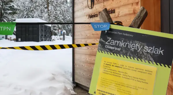 Tablica informacyjna "Zamknięty szlak" w Tatrach zimą, z taśmą ostrzegawczą.