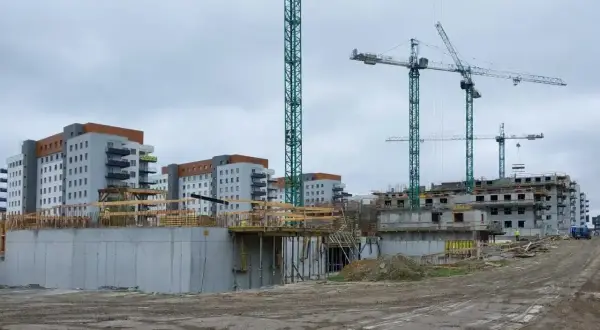 Budowa osiedla mieszkaniowego, gdzieś tu może być odpowiedź, jak dostać mieszkanie z wojska. Dźwigi i budynki w tle.