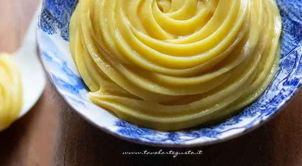 Crema pasticcera senza uova, liscia e vellutata, servita in una ciotola decorata con motivi blu.