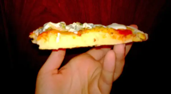 Kawałek puszystej pizzy z serem i sosem, wygląda jak pizza jak z Pizza Hut.