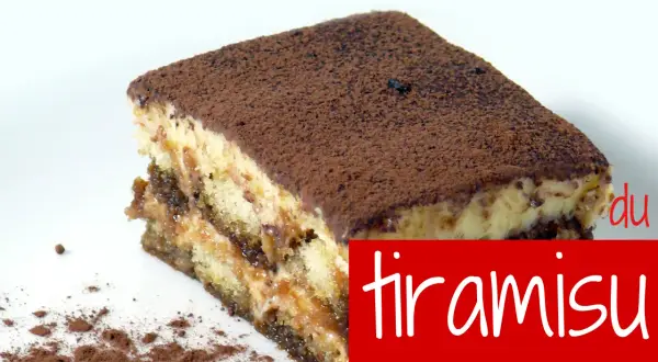 Une part de tiramisu onctueux, saupoudrée de cacao. La vraie recette du tiramisu avec sa crème liquide.