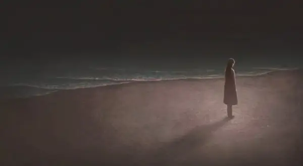 Una persona sola en la playa, contemplando el mar. Reflexiona sobre las cosas que tienes que hacer antes de morir.