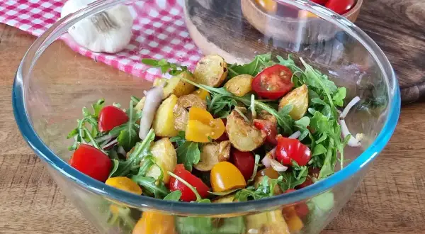 Salade colorée avec pommes de terre rôties, tomates cerises et roquette. Une option légère pour une salade pour maigrir du ventre.