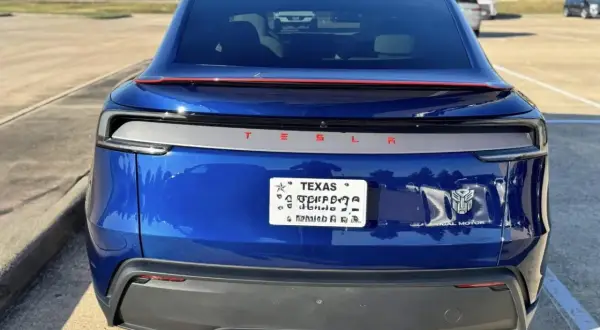Blå Tesla med registreringsskylt från Texas. En Transformers-logga sitter bredvid "Dual Motor".