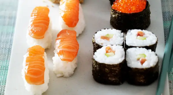 Frisches Sushi mit Lachs selber machen ist einfach! Hier Nigiri mit Lachs und Maki-Rollen mit Gurke und Lachs.
