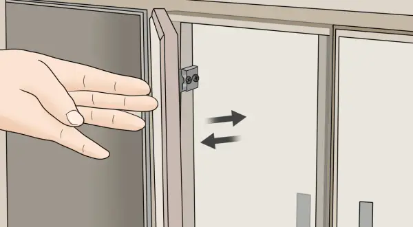 Mano ajustando la puerta de un armario con bisagras.