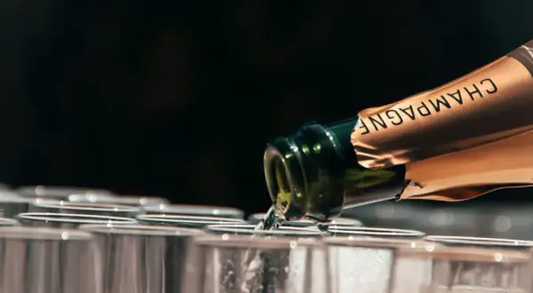 Versando champagne in bicchieri, la temperatura servizio è perfetta per un brindisi.