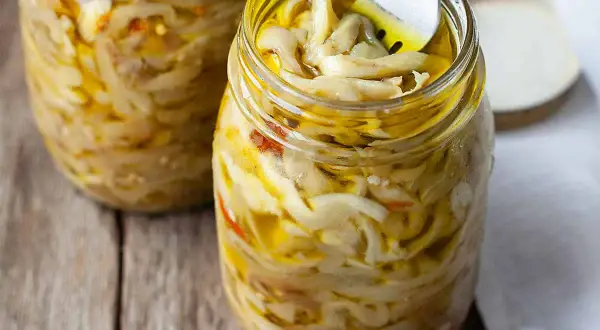 Melanzane sott'olio alla napoletana, un tesoro di sapori in barattolo. Una forchetta assaggia questa delizia.