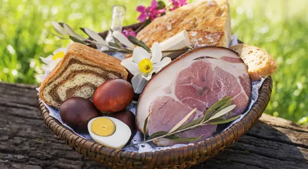 Koszyk z pieczonym mięsem, chlebem, jajkami i kwiatami. Czy w Wielką Sobotę można jeść mięso? Tradycja mówi, że nie, ale ten widok kusi!