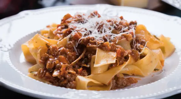 Pappardelle z sosem bolognese, posypane parmezanem. Idealny przepis na spaghetti bolognese oryginalny.