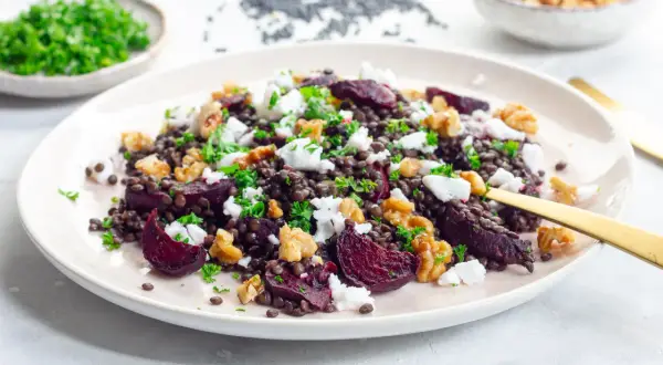 Leckerer Rote Bete-Linsen Salat mit Feta und Walnüssen, garniert mit Petersilie. Ein bunter und gesunder Genuss.