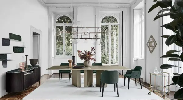 Sala da pranzo con tavolo e sedie in stile mid century modern, illuminata da un lampadario a sfere e con un mobile basso in legno scuro.