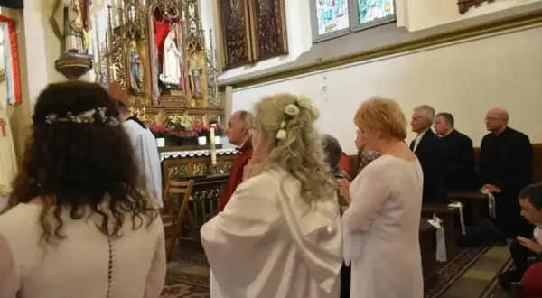 W kościele trwa uroczystość. Kobieta w białej sukni, z kwiatami we włosach, klęczy przed ołtarzem. To moment konsekracji, ważny dla każdej dziewicy konsekrowanej.