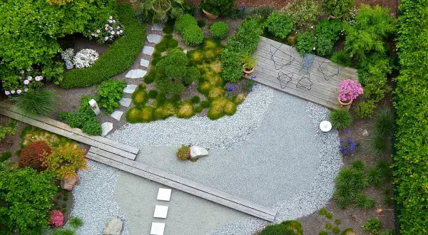 Ein moderner japanischer Garten mit Kiesflächen, Holzstegen und üppiger Bepflanzung. Tolle Garten Ideen für eine Oase der Ruhe.