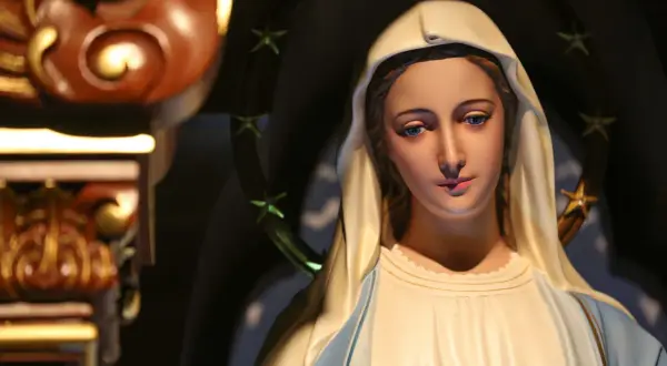 Figurka Matki Boskiej z błękitnymi oczami i aureolą gwiazd. Zastanawiamy się, ile lat żyła Maryja, gdy patrzymy na jej spokojną twarz.