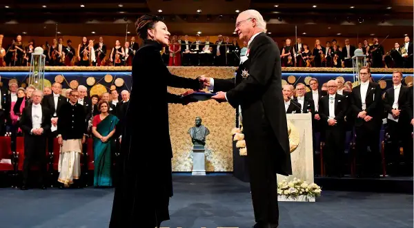 Olga Tokarczuk odbiera Nagrodę Nobla. Król Szwecji wręcza jej dyplom i medal.