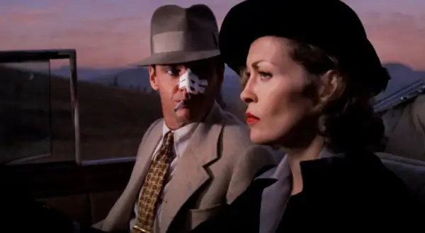 Jack Nicholson z plastrem na nosie i papierosem w ustach, obok Faye Dunaway w kapeluszu. Scena z jednego z filmów Romana Polańskiego.