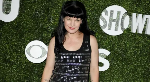 Abby Sciuto von NCIS heute: Die Schauspielerin Pauley Perrette posiert vor einem grünen Hintergrund mit CBS-Logos.