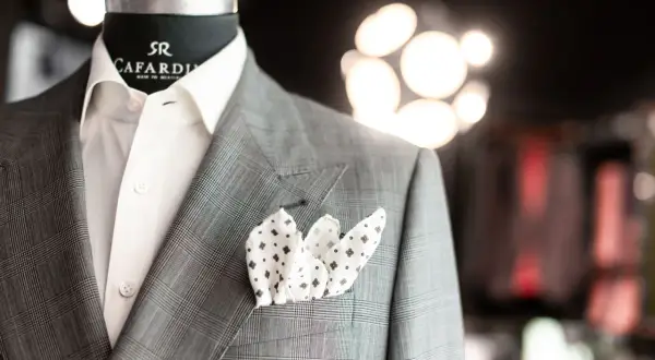 Elegancka brustasza w kratę z białą koszulą i wzorzystą poszetką.