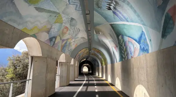 Ciclabile Riva del Garda: un tunnel artistico con affreschi colorati sul soffitto e un percorso ben segnalato.