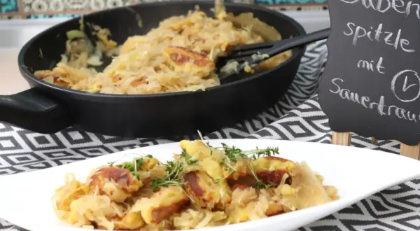 Schupfnudeln mit Sauerkraut, frisch aus der Pfanne auf einem Teller garniert mit Kräutern. Ein deftiges Gericht, das Appetit macht.