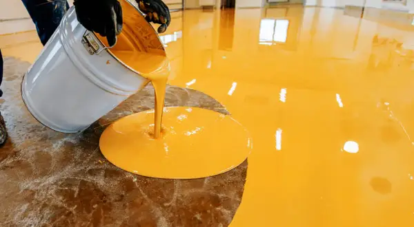 Aplicando resina epoxi amarilla en un suelo. El proceso de como aplicar resina epoxi en suelos es sencillo.