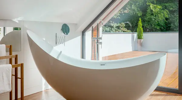 Baignoire îlot moderne, en acier ou acrylique, avec vue sur la nature.
