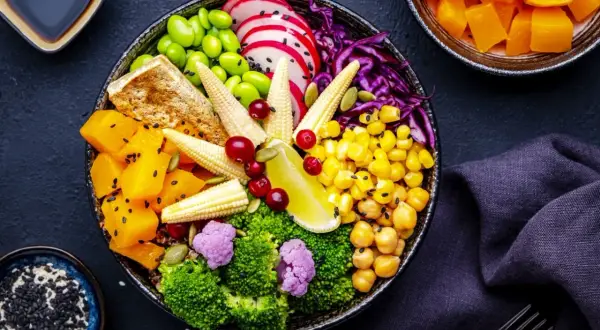 Kolorowa sałatka poke bowl z warzywami, tofu i ziarnami.