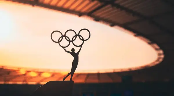Sylwetka sportowca z pięcioma pierścieniami symbolizuje pierwsze igrzyska olimpijskie.
