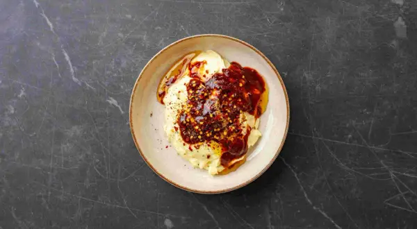 Kremowe puree ziemniaczane polane pikantnym sosem chipotle, posypane płatkami chili.