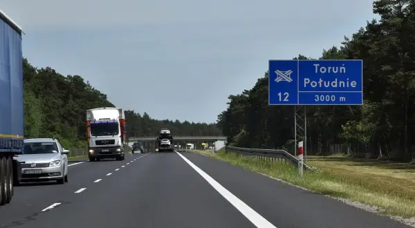 Droga ekspresowa S12 w kierunku Toruń Południe. W oddali widać wiadukt i inne pojazdy.
