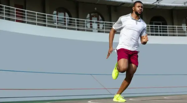 Mężczyzna w sportowym stroju biegnie po bieżni. Zastanawiasz się, jak szybko biega Usain Bolt? Ten zawodnik daje z siebie wszystko!