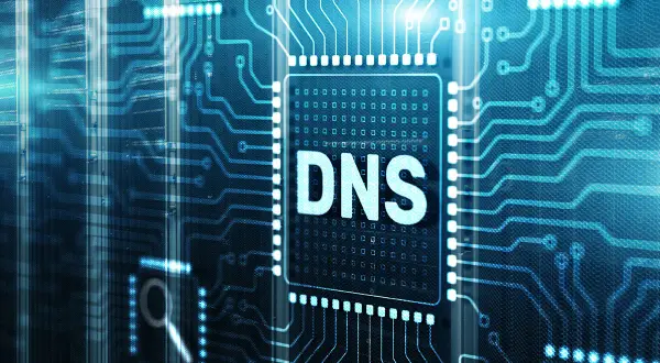Cyfrowy układ scalony z napisem "DNS" w centrum. W tle widać serwerownie, sugerując, że serwer DNS nie odpowiada.