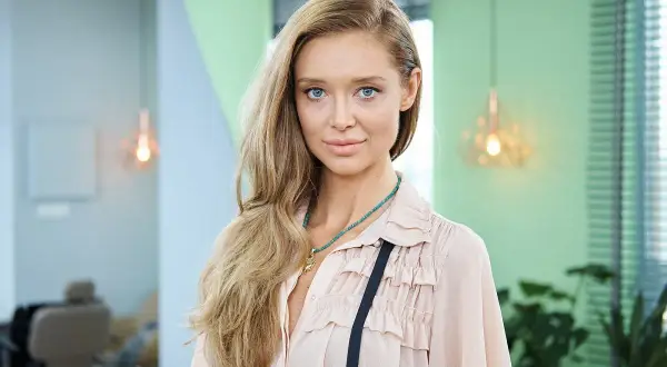 Kaja Funez Sokoła, młoda kobieta z długimi blond włosami i niebieskimi oczami, w pastelowej bluzce z falbankami.