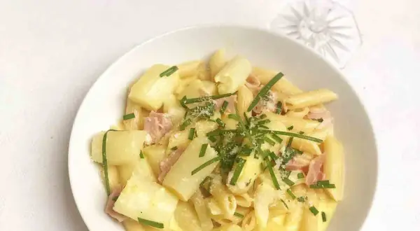 Cremige Spargel Carbonara mit Penne, Schinken und frischem Schnittlauch garniert. Ein Genuss für jeden Gaumen!