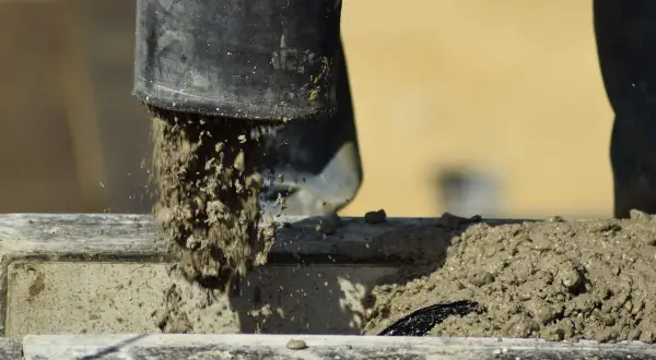 Beton wylewany z rury, rozpoczyna się proces wiązania. Czas, ile schnie suchy beton, zależy od wielu czynników.