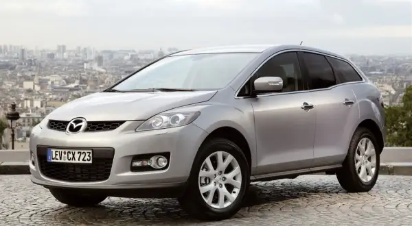 Srebrna Mazda CX7 na tle paryskiego krajobrazu. Stylowy SUV gotowy na miejskie przygody.