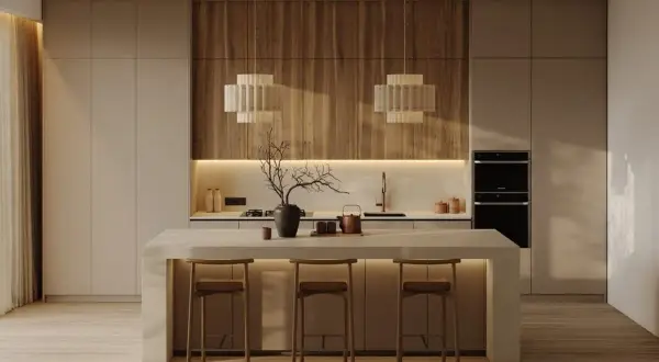 Cocina moderna con minimalismo cálido. Isla central con taburetes, encimeras de madera y luces tenues.