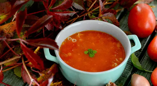Jesienny przepis na zupę pomidorową. Aromatyczna, rozgrzewająca zupa z pomidorów, podana z listkami bazylii.